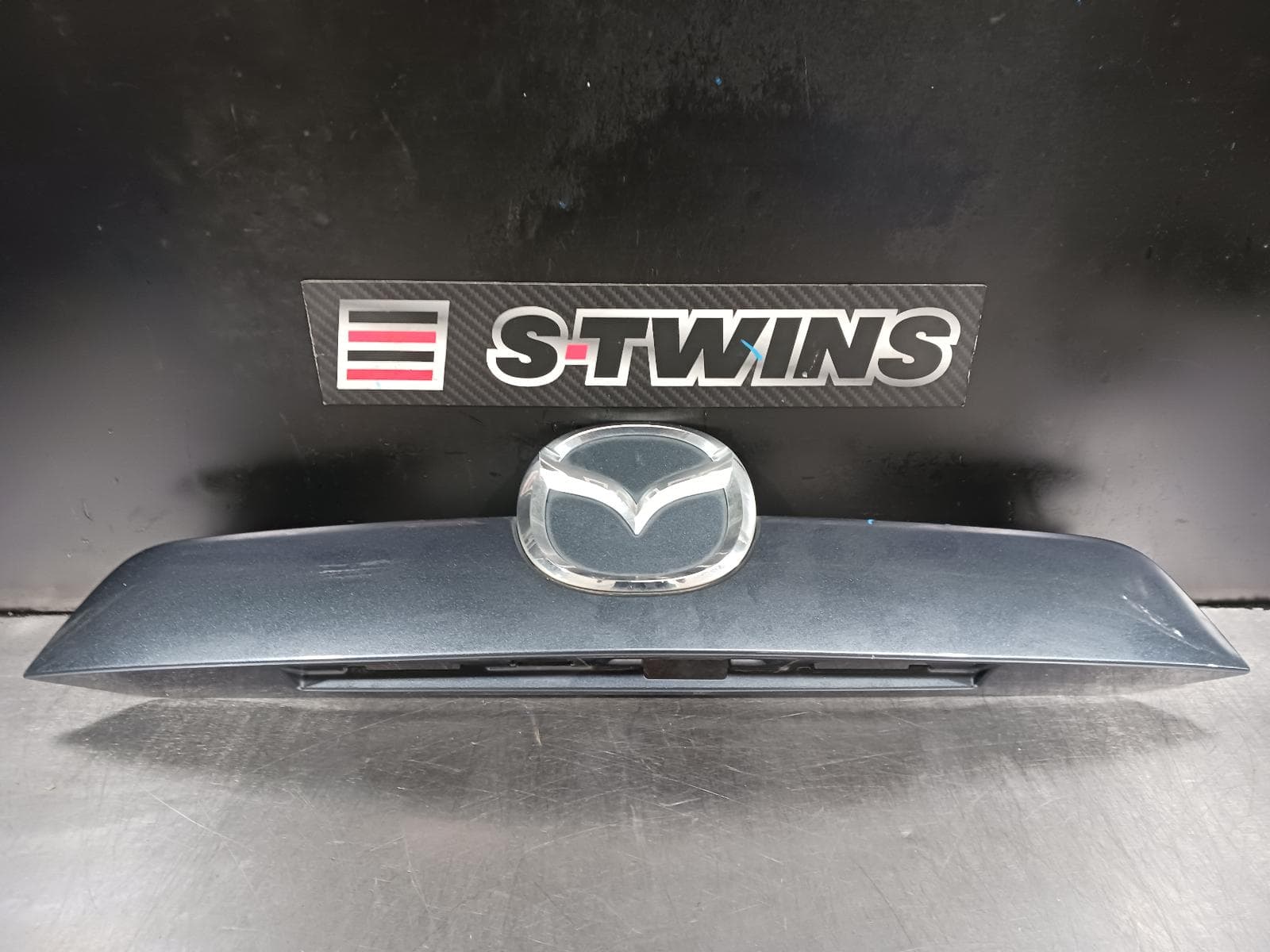 Used auto part listing image: 2012 MAZDA CX5 REAR GARNISH TAILGATE GARNISH (CENTRE), W/ REV CAMERA, NON SUNROOF TYPE, 02/12-12/16 0000235532