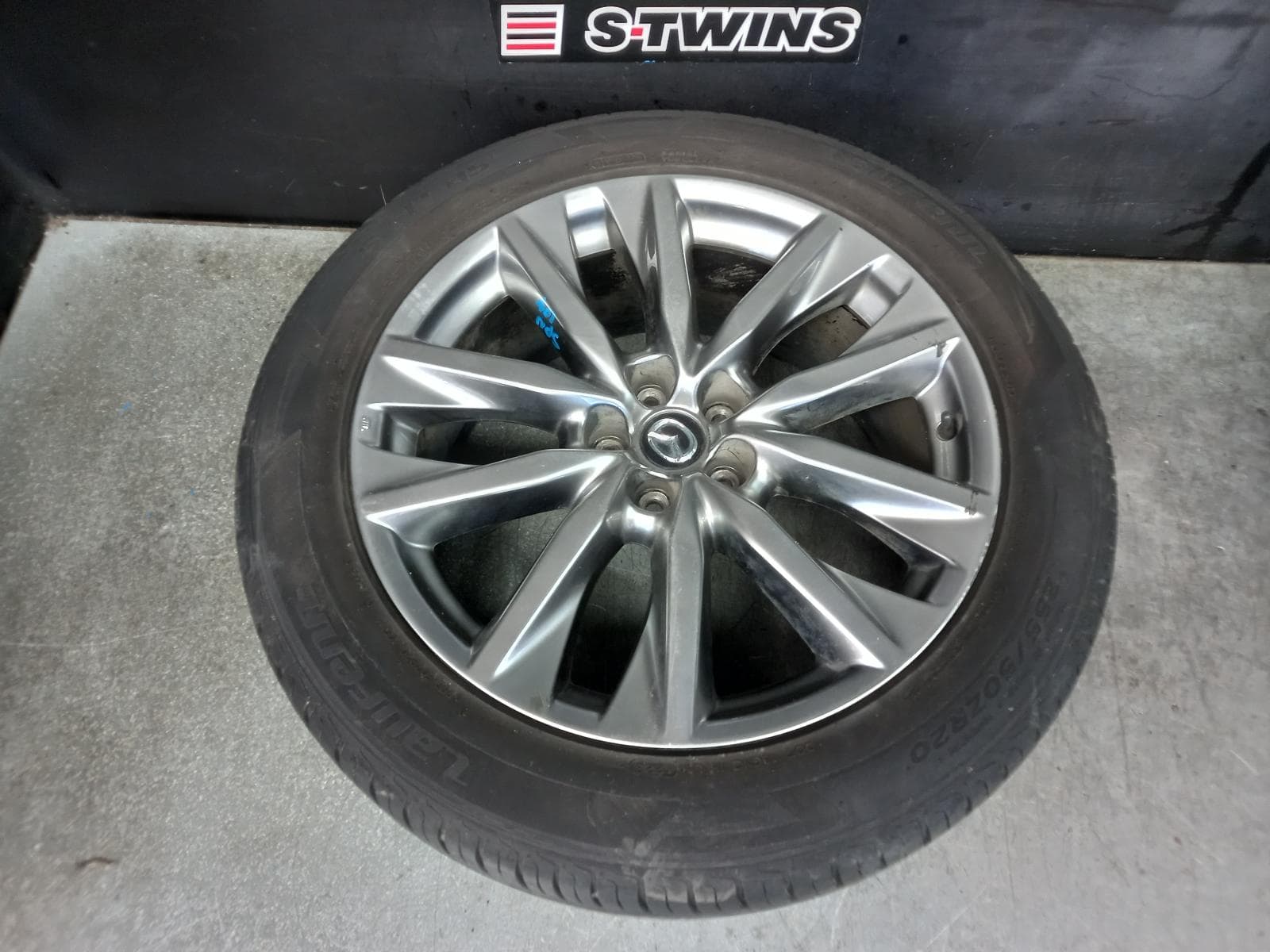 Used auto part listing image: 2016 MAZDA CX9 WHEEL MAG FACTORY, 20X8.5IN, 5 V SPOKE, LIGHT GREY, TC, 07/16-12/24 0000365251