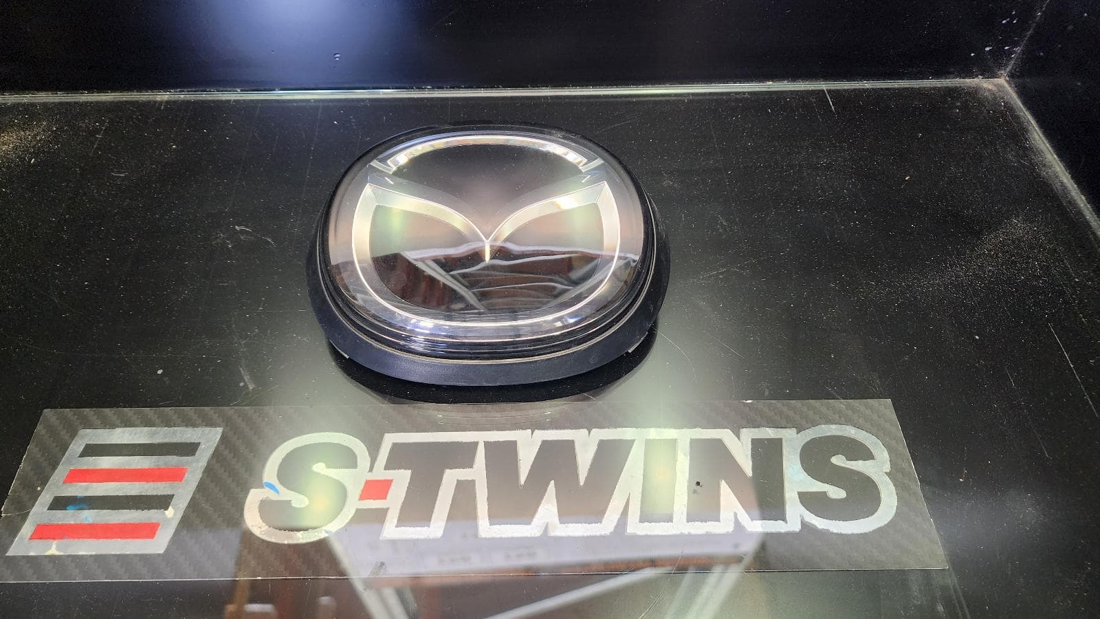 Used auto part listing image: 2022 MAZDA 3 MISC BP, 03/19- 0000370037 GRILLE BADGE (RADAR TYPE)