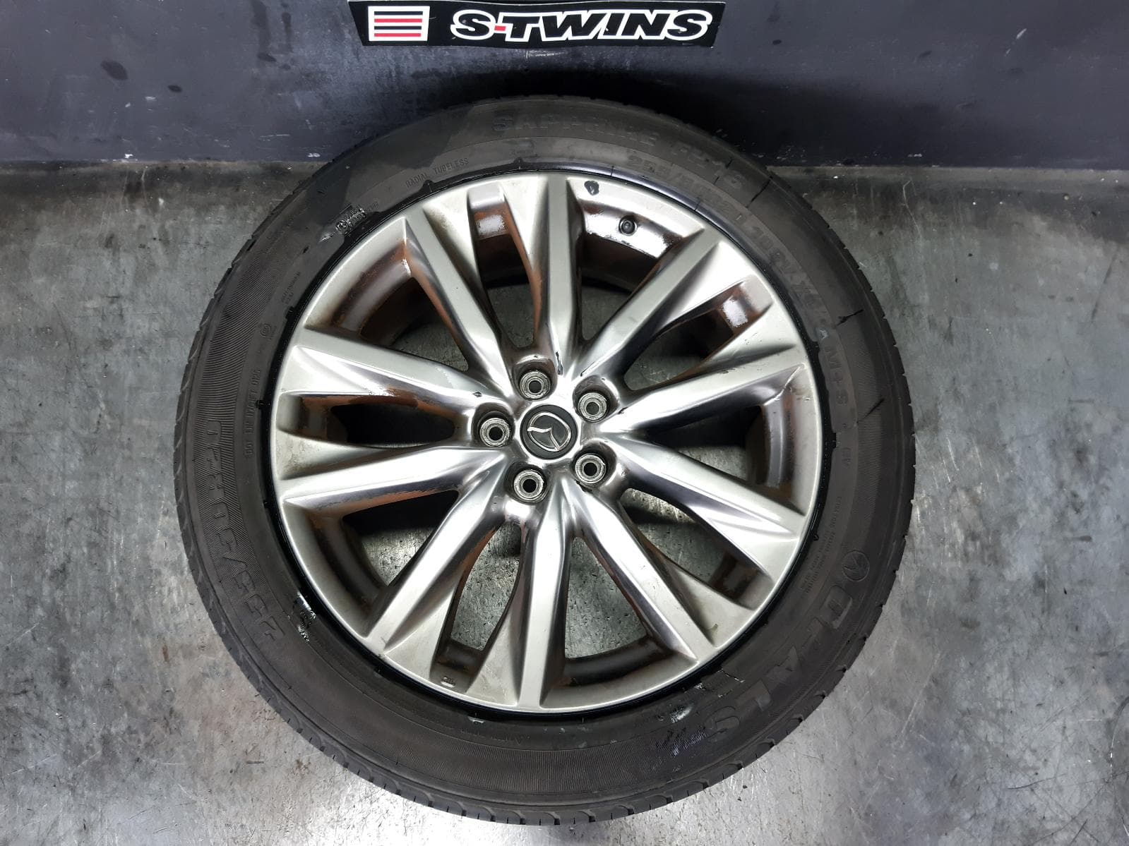 Used auto part listing image: 2016 MAZDA CX9 WHEEL MAG FACTORY, 20X8.5IN, 5 V SPOKE, LIGHT GREY, TC, 07/16-12/24 0000371917