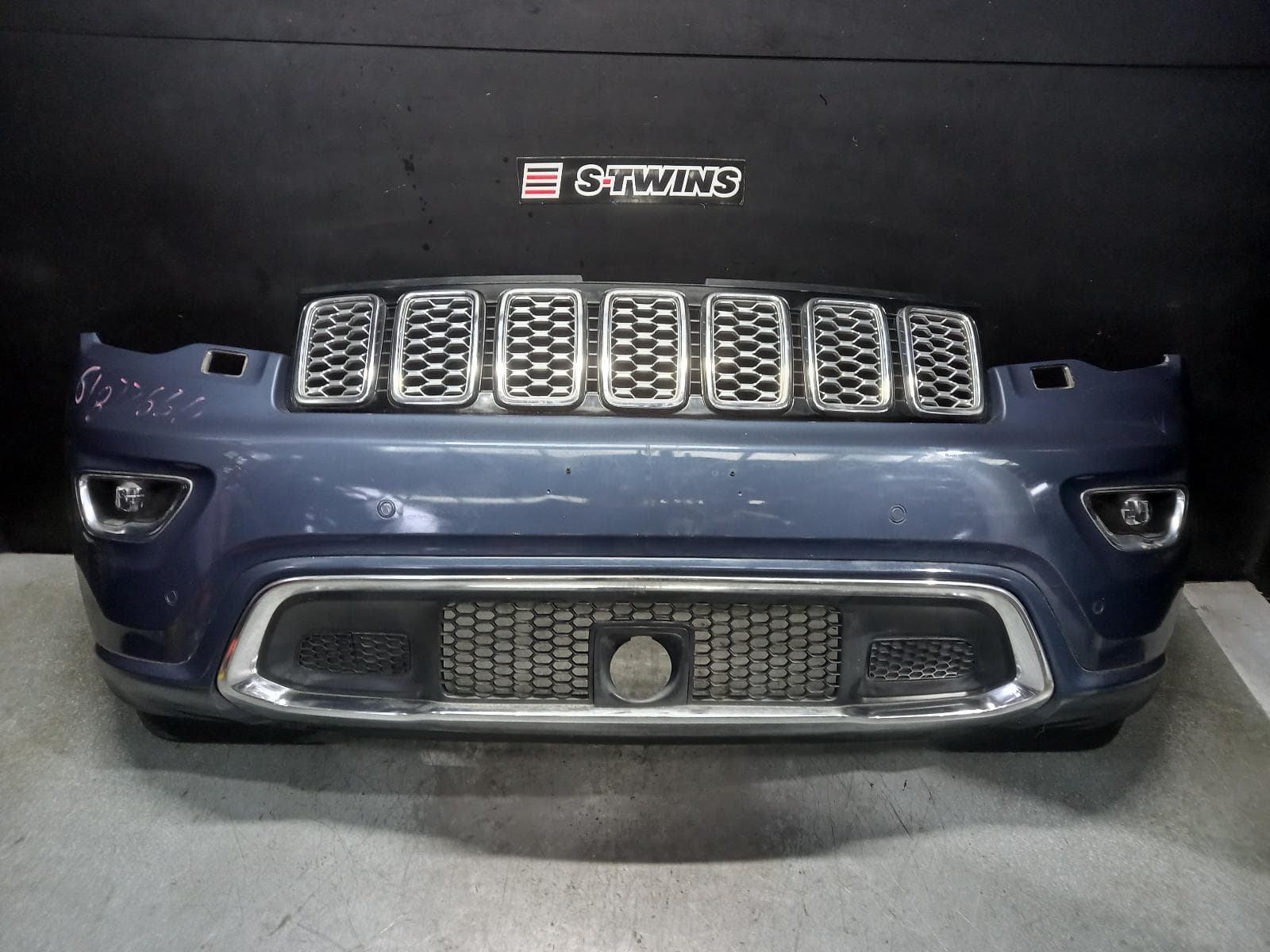 Used auto part listing image: 2021 JEEP GRANDCHEROKEE FRONT BUMPER WK, BUMPER BAR (2 PIECE), OVERLAND/25TH ANNIV, W/ PARALLEL & PERPENDICULAR PARK ASSIST TYPE, 09/16-02/22 0000386663