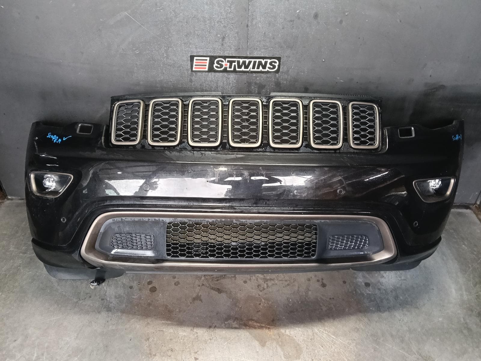Used auto part listing image: 2017 JEEP GRANDCHEROKEE FRONT BUMPER WK, BUMPER BAR (2 PIECE), BLACKHAWK/NIGHT EAGLE, W/ PARALLEL & PERPENDICULAR PARK ASSIST TYPE, 09/16-02/22 0000403059