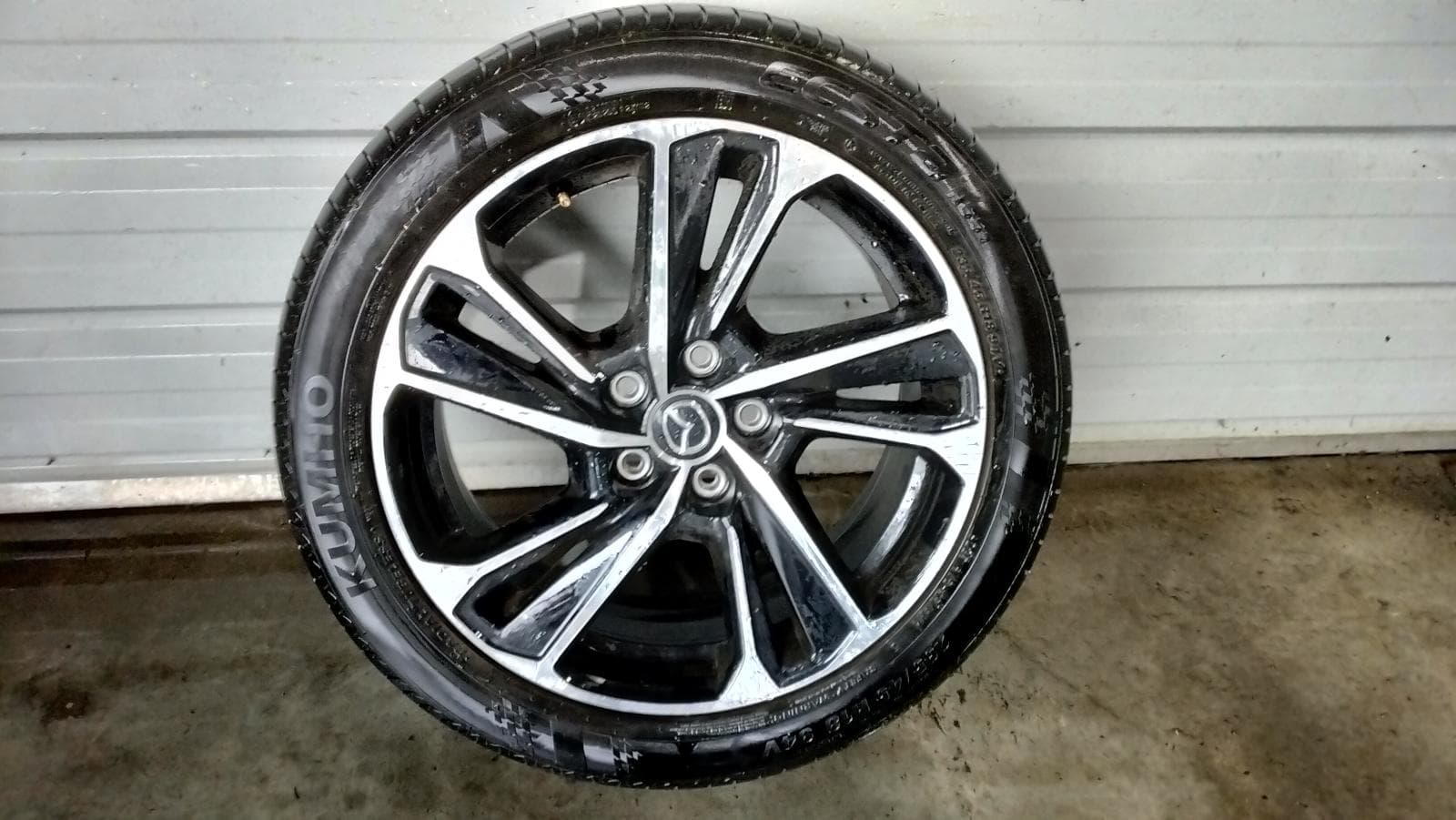 Used auto part listing image: 2024 MAZDA CX3 WHEEL MAG FACTORY, 18X7IN, 5 V SPOKE, BI-COLOUR, DK, 01/21- 0000408430