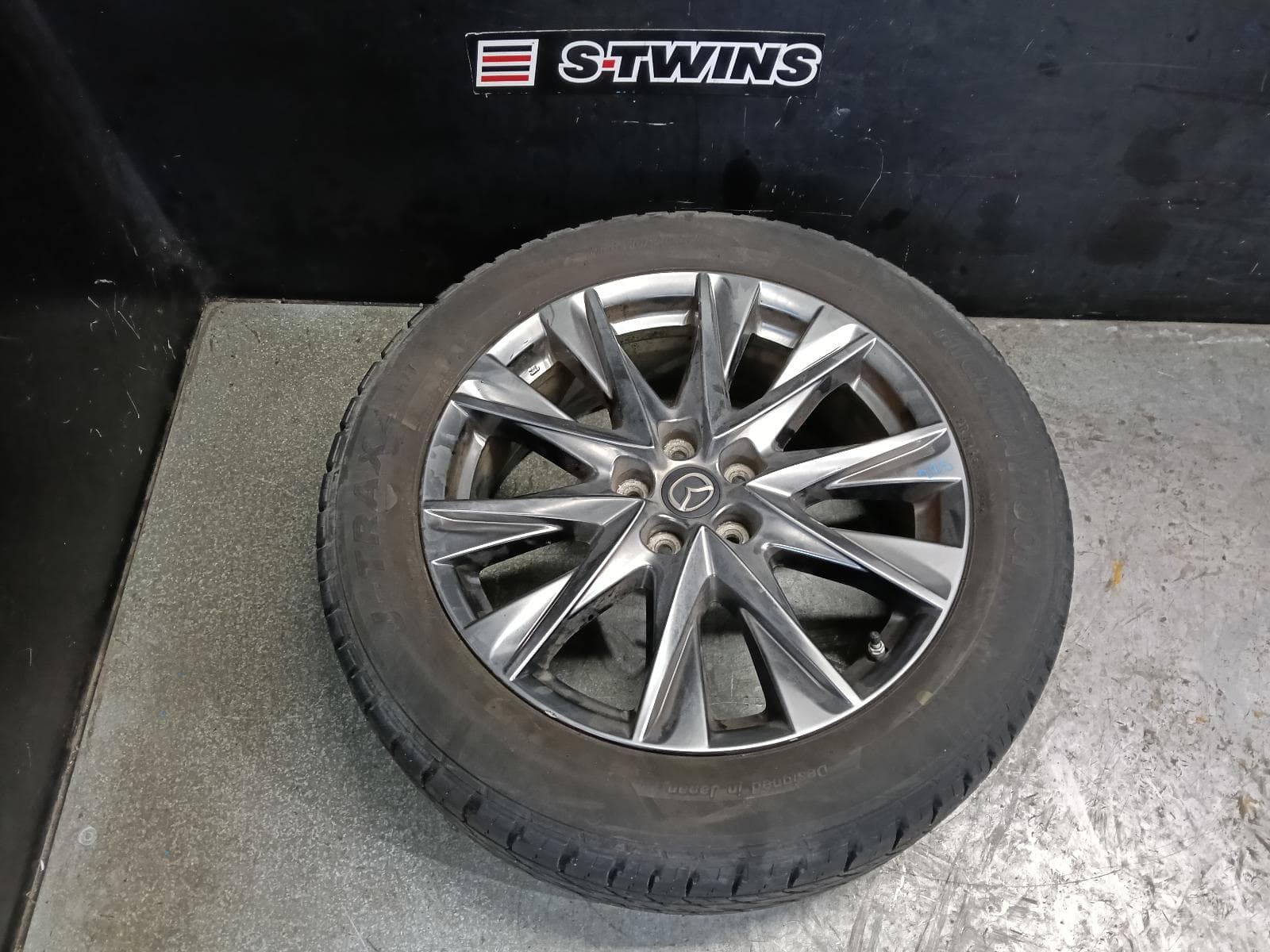 Used auto part listing image: 2019 MAZDA CX5 WHEEL MAG FACTORY, 19X7IN, 5 V SPOKE, LIGHT GREY, KF, 05/18-03/26 0000415859