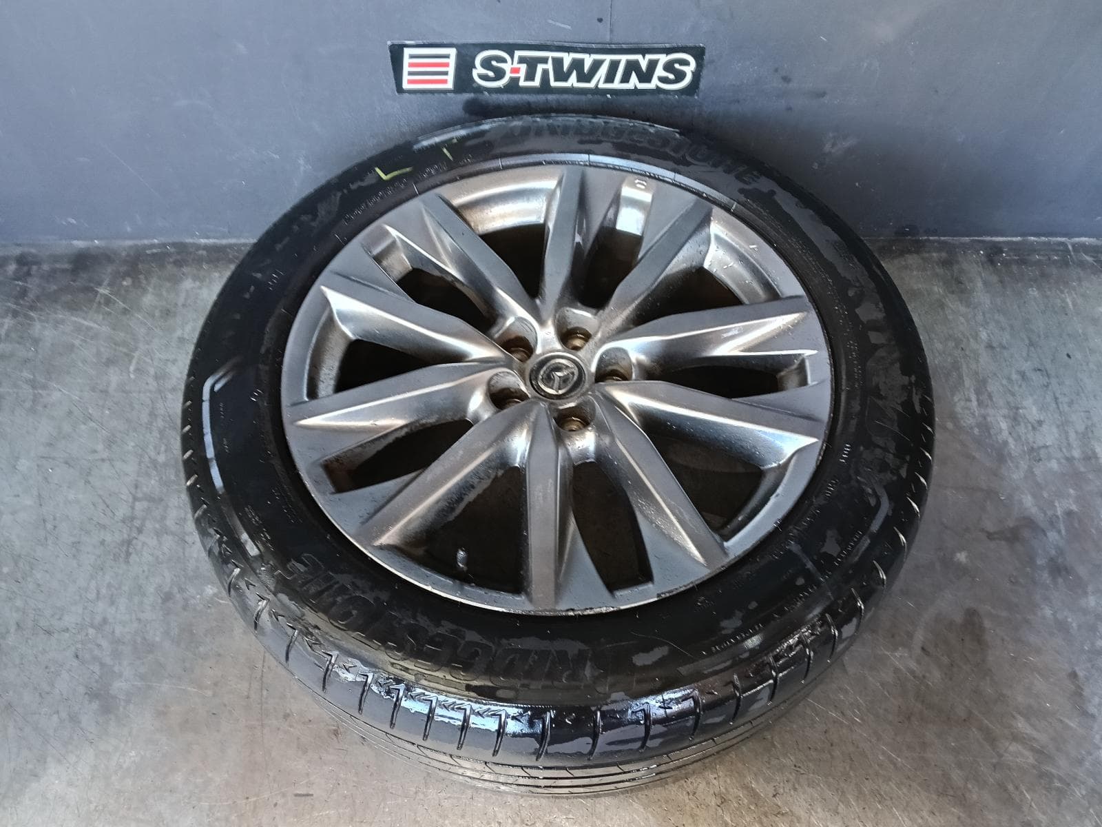 Used auto part listing image: 2017 MAZDA CX9 WHEEL MAG FACTORY, 20X8.5IN, 5 V SPOKE, LIGHT GREY, TC, 07/16-12/24 0000416223