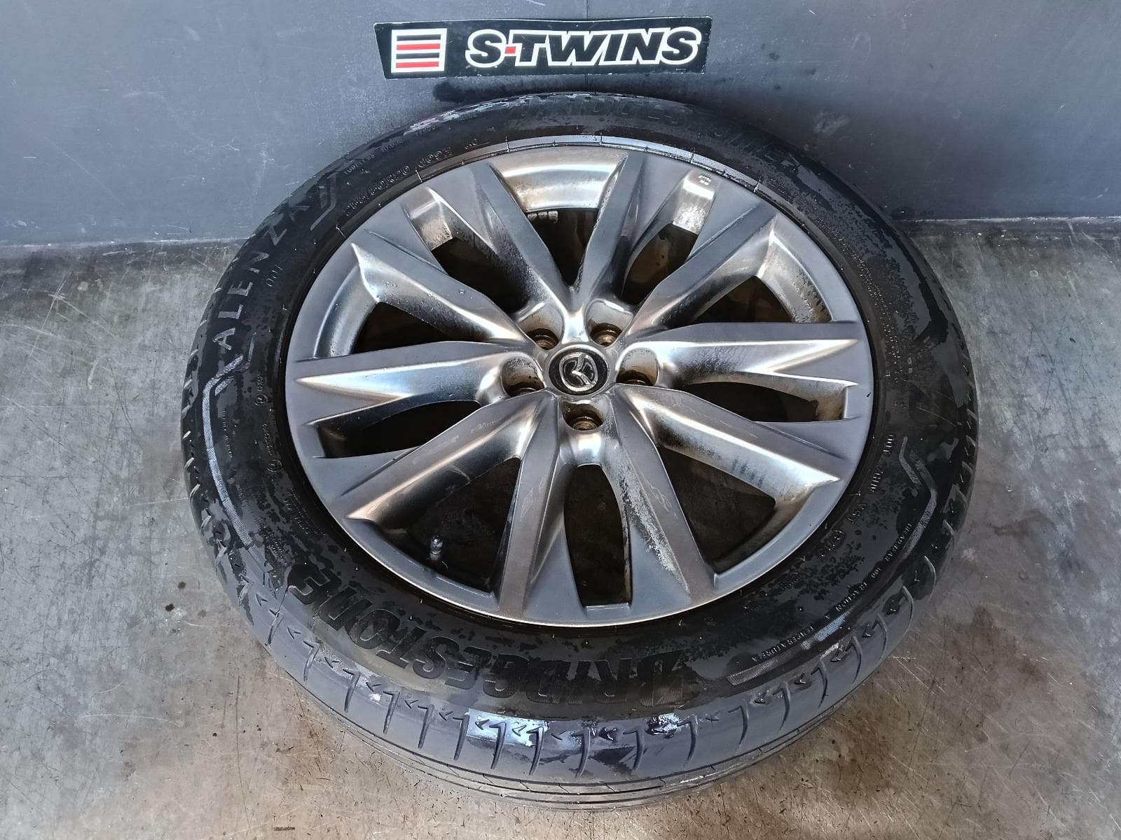 Used auto part listing image: 2017 MAZDA CX9 WHEEL MAG FACTORY, 20X8.5IN, 5 V SPOKE, LIGHT GREY, TC, 07/16-12/24 0000416225