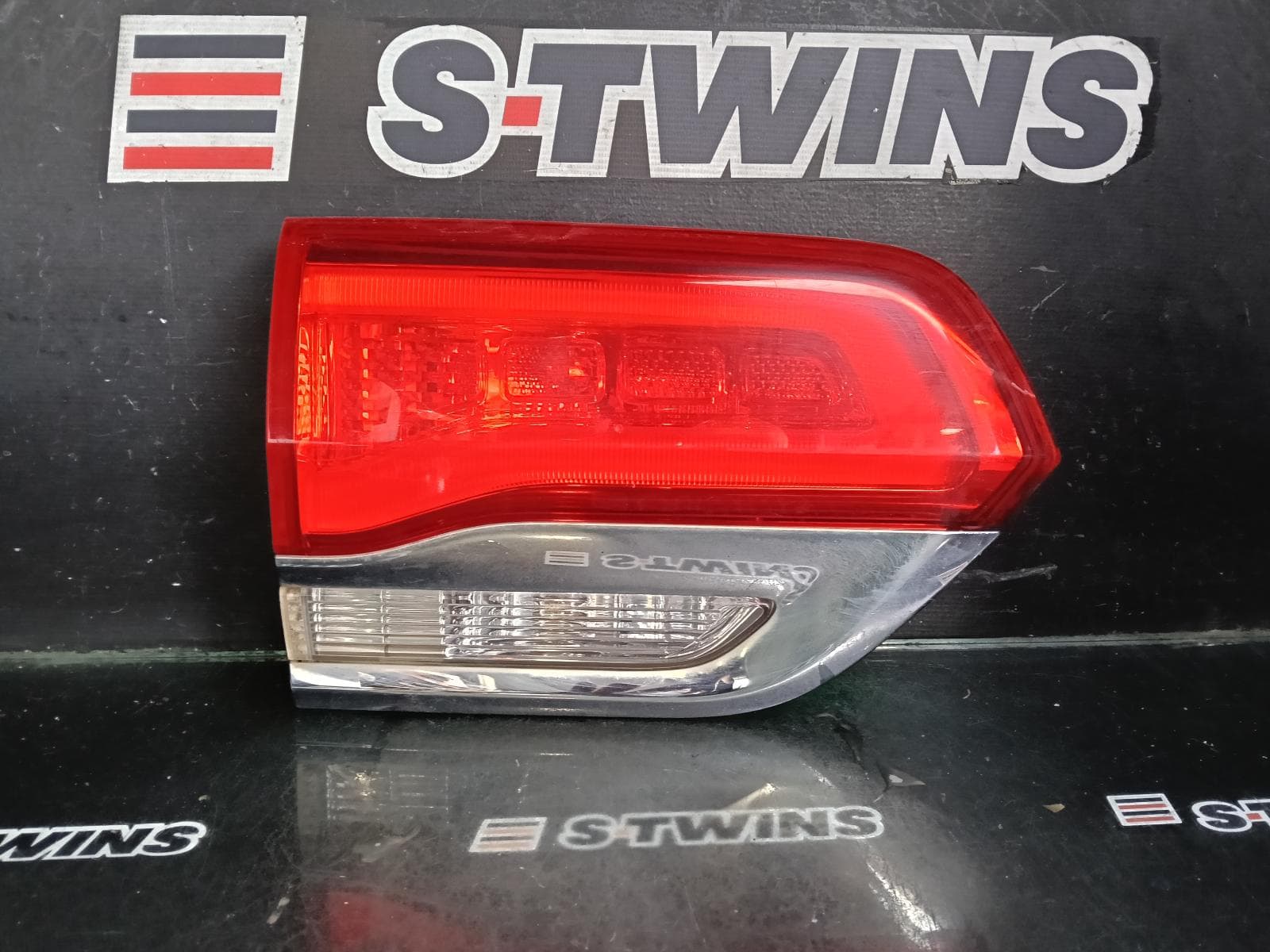 Used auto part listing image: 2016 JEEP GRANDCHEROKEE REAR GARNISH TAILGATE LAMP (LH SIDE), WK, LAREDO/OVERLAND/SUMMIT/LIMITED, CHROME BEZEL, 04/13-02/22 0000429855